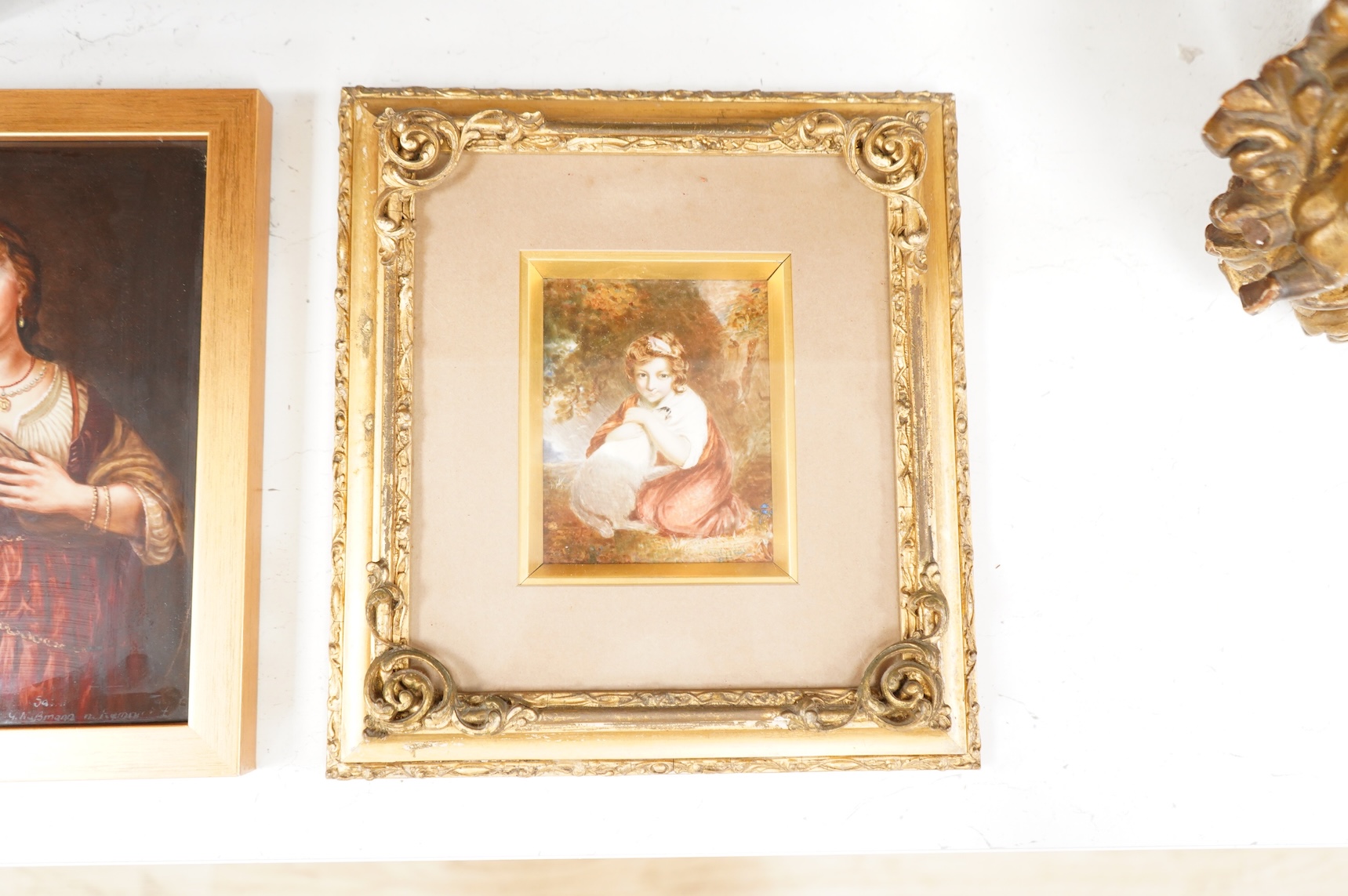 A Continental painted porcelain plaque of Saskia van Uylenburgh, after Rembrandt, together with another plaque of a young girl and her dog, after John Russell (2), Largest 17cm wide x 24cm high.